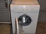 a washing machine with a basket on top of it