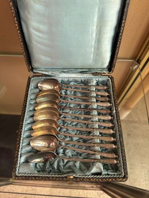 silverware in a case with a silver handle and spoons in it