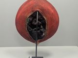 a red hat on a metal stand with a hole in it