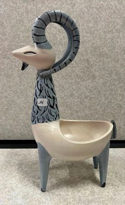 un animal en céramique assis par terre