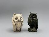 deux petites figurines de chouettes assises l'une à côté de l'autre