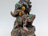 une image représentant la statue d'un homme assis sur un rocher