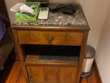 a nightstand with a phone on top of it on a wooden floor