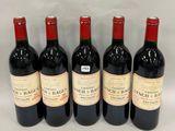 six bottles of red wine are lined up on a white surface