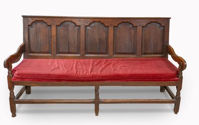 un banc en bois sur lequel est posé un coussin rouge