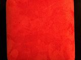a red cushion on a black surface