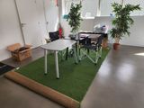a room with a table, chairs, and a rug on the floor