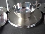 a silver plate with a spoon and a bowl on it