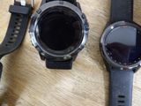 two smart watches sitting next to each other on a wooden table