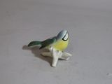 a small figurine of a bird sitting on a table