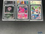quatre cartes à collectionner Pokémon différentes, présentées dans des étuis en plastique transparent posés sur un fond noir