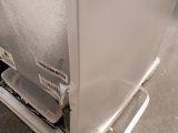 a white refrigerator sitting on the floor next to a wall