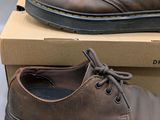 pair of brown shoes sitting on top of a box on top of a table