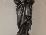 statue en bronze représentant une femme tenant un enfant dans ses bras, posée sur un socle