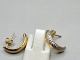 two pairs of gold and silver earrings on a white surface