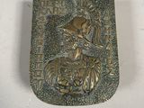 an old metal belt buckle with a picture of a woman on a horse