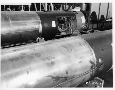 photographie en noir et blanc d'un gros tuyau métallique dans une usine