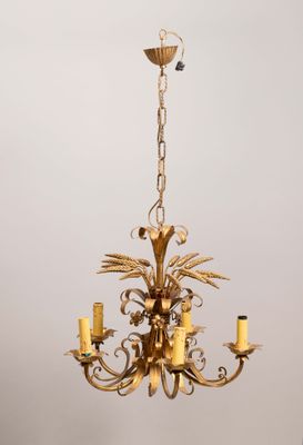 un lustre ancien en laiton, orné de cinq bougies et d'un oiseau