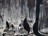 a lot of wine glasses and a pitcher on a table
