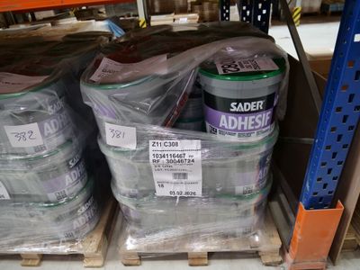 many cans of adhesives on a pallet in a store