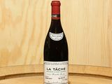 a bottle of wine sitting on top of a barrel