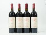 trois bouteilles de vin rouge posées sur une table blanche