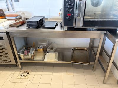 une grande table en inox sur laquelle est posé un micro-ondes