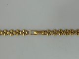 a close up of a gold bracelet on a white surface