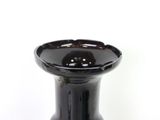 a black vase that is sitting on a white surface