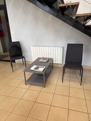 two black chairs and a coffee table in a living room