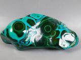 sculpture en verre vert et noir représentant un poisson sur un fond blanc