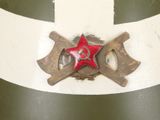 a picture of a red star and two crossed axes on a green and white wall