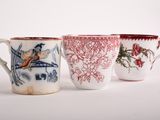 three coffee mugs with designs of birds and flowers on them