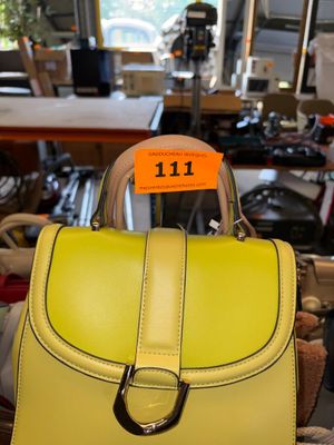 a yellow handbag with a price tag on it