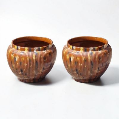 two brown vases sitting next to each other on a white surface