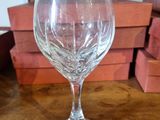 a wine glass sitting on a table with a stack of boxes in the background