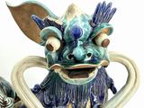 a statue of a dragon with a flower in its mouth