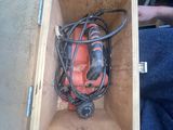 une boîte contenant une perceuse et une cordelette