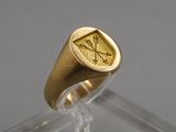 une image représentant une bague en or ornée d'un symbole maçonnique