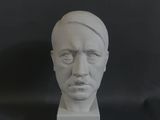 une sculpture blanche représentant le visage d'un homme sur fond noir