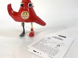 un oiseau rouge posé à côté d'une feuille de papier