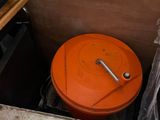 an orange bucket sitting in the corner of a room