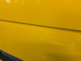 a close up of a yellow car with a black door handle