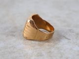 a close up of a gold ring on a marble surface