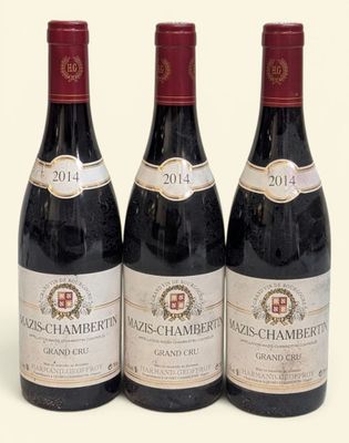trois bouteilles de vin sont alignées sur une surface blanche