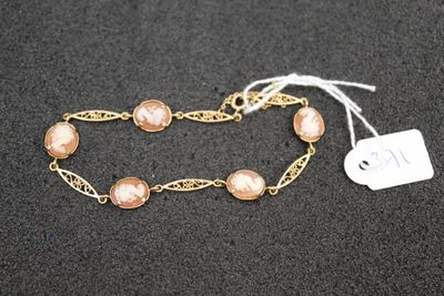 a close up of a gold chain bracelet with pearls on it