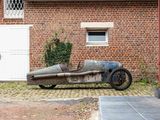 an old car that is parked in front of a brick building