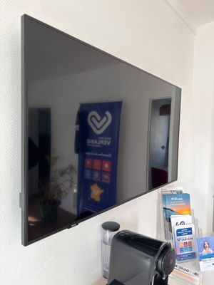 a coffee maker sitting on a counter in front of a large mirror