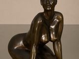statue en bronze représentant une femme assise par terre, les mains posées sur les genoux