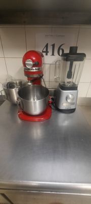 un mixeur rouge posé sur un plan de travail de cuisine, avec un bol mixeur